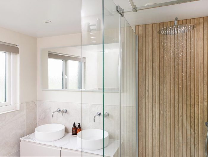 A drench shower head set up in a bathroom with two sinks