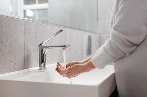 Someone washing their hands in a bathroom sink