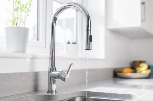 A kitchen tap running water with very low pressure